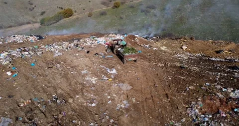 Garbage transportation by tractor pulling a trailer on rural road. Landfill d Stock Footage 296071227