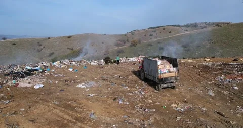 Garbage transportation by tractor pulling a trailer on rural road. Landfill d Stock Footage 310336755