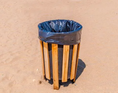 Garbage trash can on a clean beach close Stock Photos