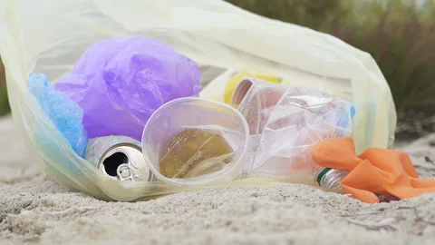 Garbage trash lies in the plastic bag, at sea beach. Slowmotion. Video stock 116020567