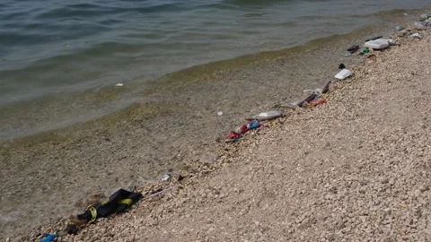 Garbage trash plastic being washed to the shore Stock Footage 300067050