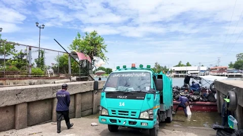 Garbage Truck Loading Waste from Boat at River Dock Stock Footage 339546688