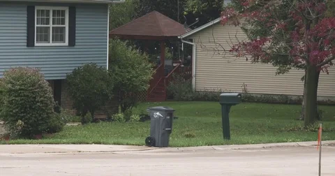 Garbage Truck Pulls Up to House and Grabs Garbage Can Stock Footage 81005911