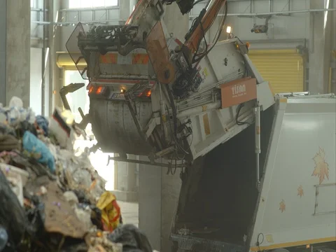 A garbage truck retracts mechanically the rear door Stock Footage
