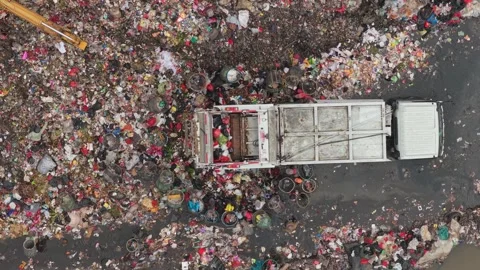 Garbage truck unloading waste at a polluted landfill site Vídeos de archivo 327820693