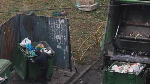 Garbage workers load garbage and waste from containers into a garbage truck.. 库存影片 291809006