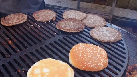 Garden barbecue turning hamburger patties Stock Footage