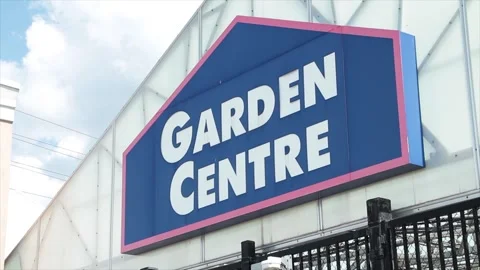 Garden centre sign on front of building top with black fence below, blue white Stock Footage 249096904