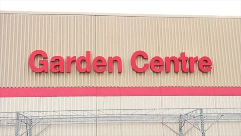 Garden centre writing caption text on beige wall building above red line in red Stock Footage 249759574