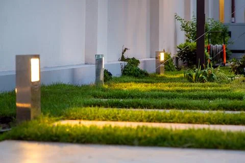 Garden decorative lantern lighting marble walkway in the evening backyard. Stock Photos