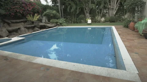 A garden fitted with a big pool and tropical trees Stock-Footage 48788060