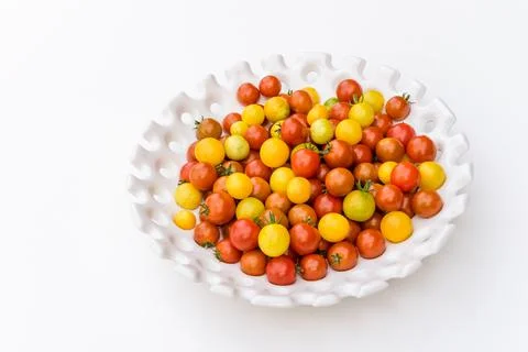 Garden harvest of yellow and red cherry tomatoes on white tray Stock Photos