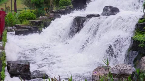 Garden multi-layered waterfall landscape next to red railing Stock Footage 340800535