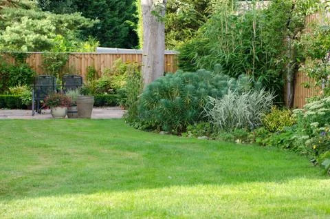 Garden with patio area, lawn and flowerbeds. Stock Photos