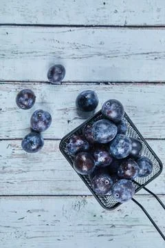 Garden plums on a blue table Stock Photos