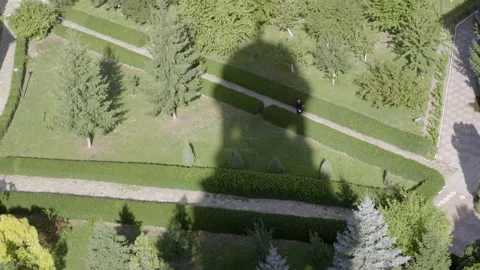 Garden with priest walking through shadow of a tower Video stock 141196986