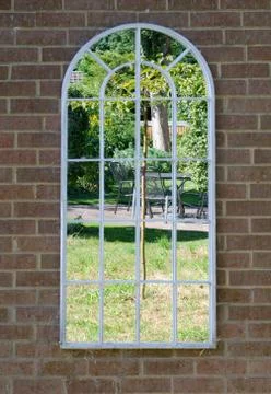 Garden reflected in mirror on a wall Stock Photos