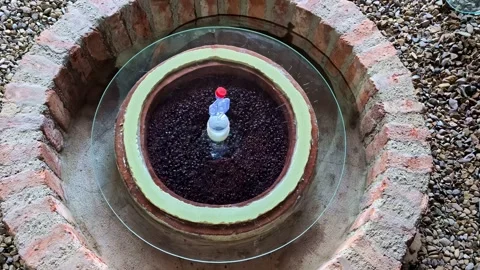 Garden water feature circular brick-walled base dark clay pot filled with Vidéo 336946767