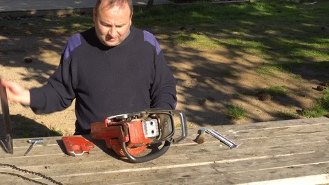 Garden worker doing the maintenance of a chainsaw Stock Footage 107054808