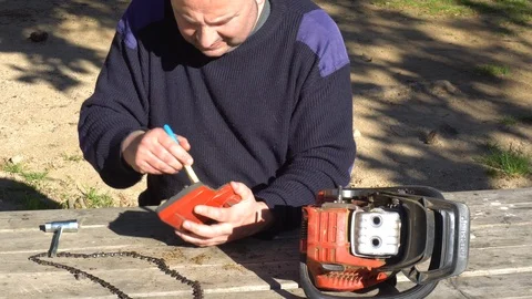 Garden worker doing the maintenance of a chainsaw Stock Footage 107054892