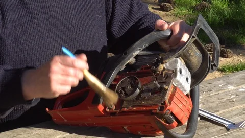 Garden worker doing the maintenance of a chainsaw Stock Footage 107054997