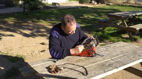 Garden worker doing the maintenance of a chainsaw Stock Footage 107055052