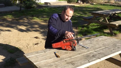 Garden worker doing the maintenance of a chainsaw Stock Footage 107055066