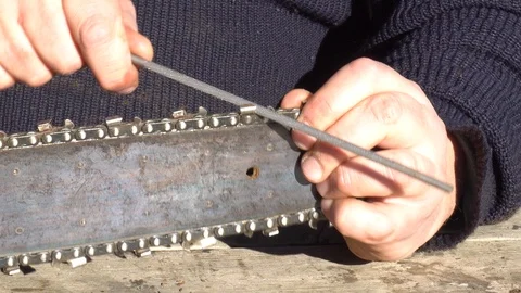 Garden worker doing the maintenance of a chainsaw Stock Footage 107055162