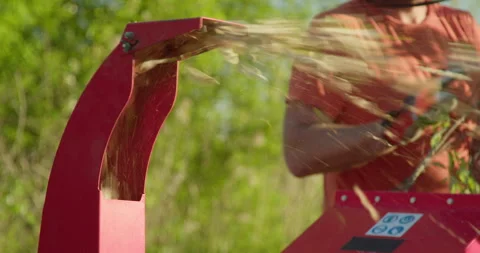Garden worker using wood chipper shredder machine for making mulch Stock Footage 301229039