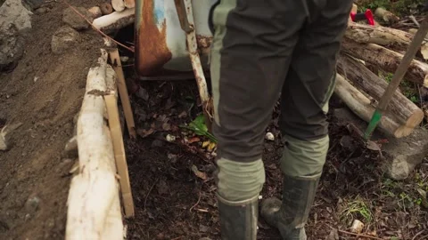 Gardener Dumping Dried Leaves Using Wheelbarrow Into Compost Pit  For Stock Footage 242175639