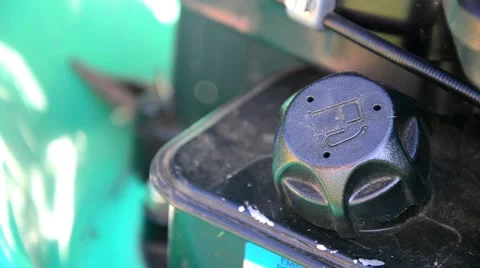 Gardener hand fill empty grass lawn cutter mower fuel tank. Filling lawnmowers Stock Footage 52340608