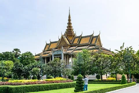 Gardener maintaining hedges in front of the throne hall of the royal palace in Stock Photos