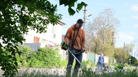 Gardener man mowing the grass Stock Footage 241408733