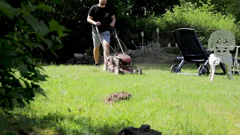 Gardener mowing the grass in the backyard. 스톡 동영상 131618379