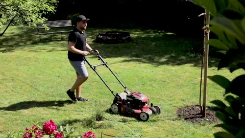 Gardener mowing the grass in the backyard. Stock Footage 131618796