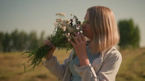 Gardener Smiling While Smelling Fresh Wildflowers in Serene Farmland Setting Stock-Footage 293451525