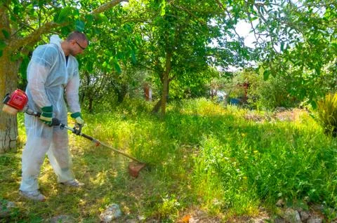 Gardener using brush cutter Stock Photos