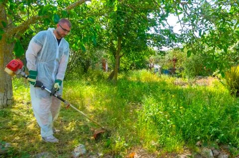 Gardener using brush cutter Stock Photos
