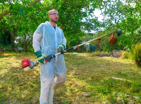 Gardener using brush cutter Stock Photos
