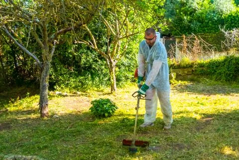Gardener using brush cutter Stock Photos