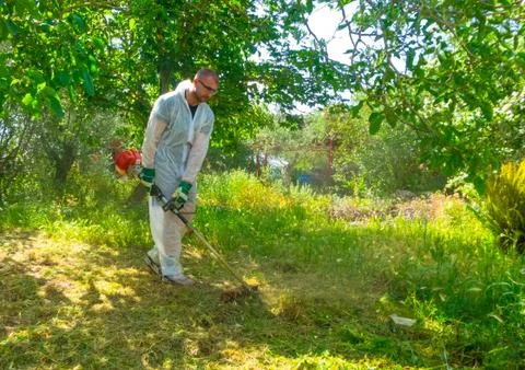 Gardener using brush cutter Stock Photos