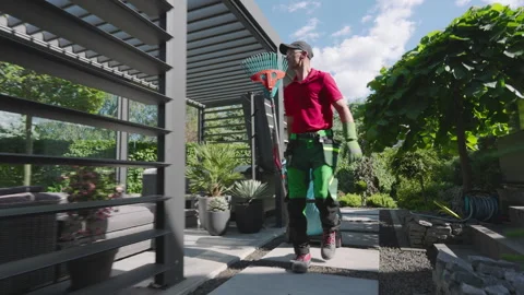 Gardener Using Leaf Blower in Garden on Sunny Day Stock Footage 277850859