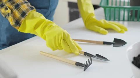 The gardener's hands lay out the tools for transplanting flowerpots on table Stock Footage 242001453