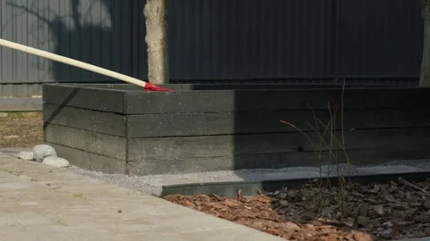Gardening preparation with rake and raised planter box in sunny backyard Stock Footage 331474656
