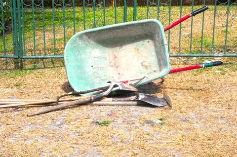 Gardening tools left by the front gate of a house Stock Photos