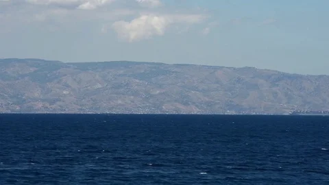 Gargo ship passes on the Strait of Messina passing near the coast of Calabria Stock-Footage 83913767