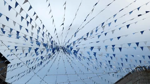 Garland with coloured flags stretched between the roofs of houses. Stock Footage 111946206