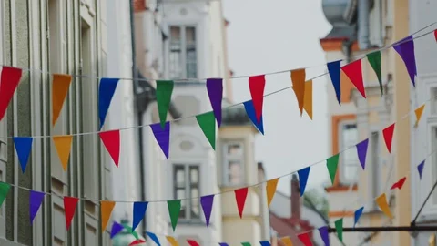 Garland of multi-colored flags in old town on blurred architecture background 库存影片 129339112