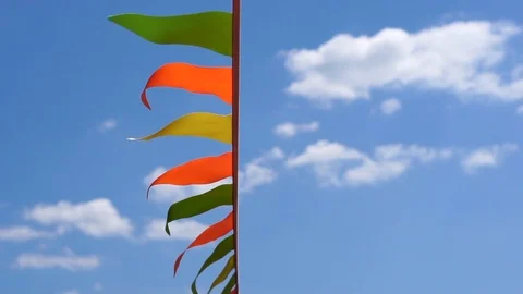 Garland of multi colored flags of triangular shape sways in the blue sky Stock Footage 114139433