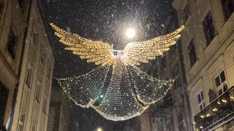 Garlands against the background of the night sky and the falling snow. Stockbeeldmateriaal 296550552